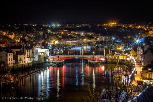 a city at night with a bridge and a river at The Lansbury - Whitby in Whitby