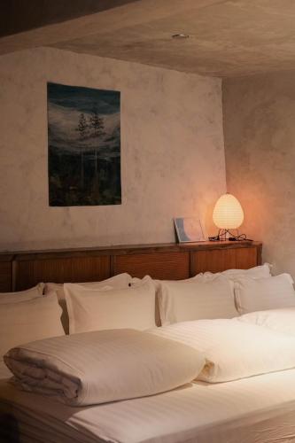 a bedroom with a bed with a lamp on it at Yu Apartment in Jiufen
