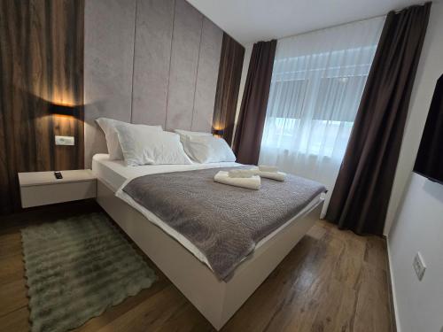 a bedroom with a bed with two towels on it at Apartman FIŠBAH II 1 self CHECK-IN, FREE PRIVATE PARKING in Osijek