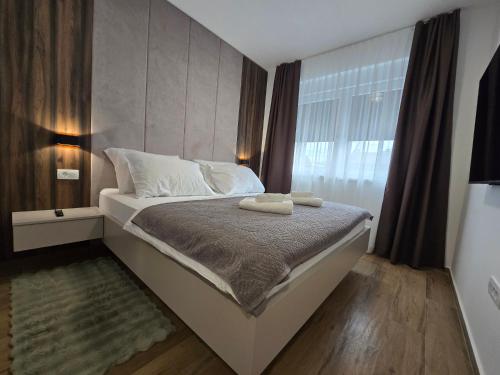 a bedroom with a bed with two towels on it at Apartman FIŠBAH II 1 self CHECK-IN, FREE PRIVATE PARKING in Osijek