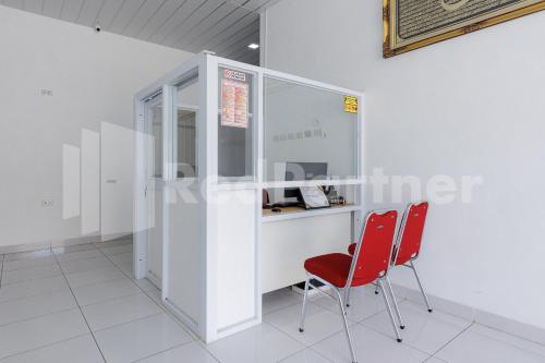 a room with two red chairs and a counter at Sanama Kostel 2 Syariah Lampung RedPartner in Lampung