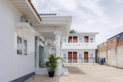 a white house with white columns and a balcony at Sanama Kostel 2 Syariah Lampung RedPartner in Lampung