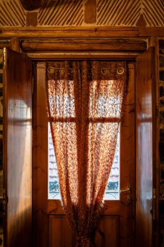 a curtain on a window in a room at 4 Seasons Premium Chalet & Massage Treatments in Palaios Agios Athanasios