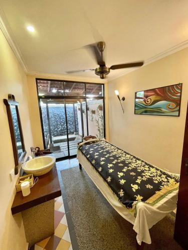 a bathroom with a bed and a sink and a window at Holiday Villa Resort & Beachclub Langkawi in Pantai Cenang