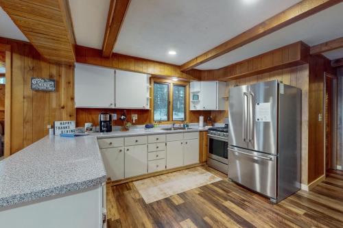 a kitchen with white cabinets and a stainless steel refrigerator at Good Time Inn in Lake Tomahawk