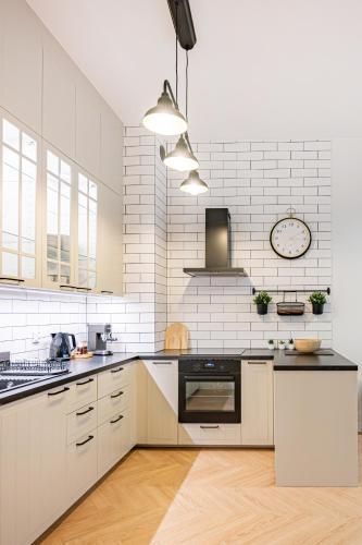 a white kitchen with a black and white appliances at Apartament Botanique in Wrocław