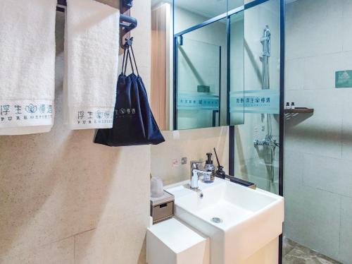 a bathroom with a sink and a shower at 浮生慢遇酒店 in Dali Airport