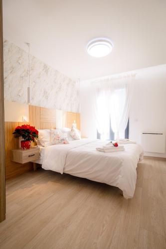 - une chambre avec un grand lit blanc orné de fleurs dans l'établissement Coup de Coeur des voyageurs - Moderne- Pro ou couple av Enfants - Entrer autonome -Les Bonn'appartts-sur-Seine, à Bonnières-sur-Seine