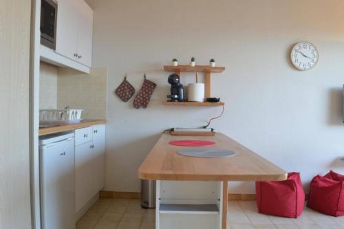 une cuisine avec une table et une horloge au mur dans l'établissement Appart studio cabine 4 couchages BANYULS SUR MER BN280-A67, à Banyuls-sur-Mer