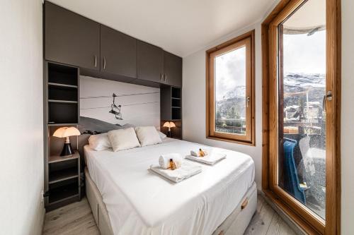une chambre avec un grand lit avec deux serviettes dessus dans l'établissement Les Cimes - Immodreams - Avoriaz, à Avoriaz