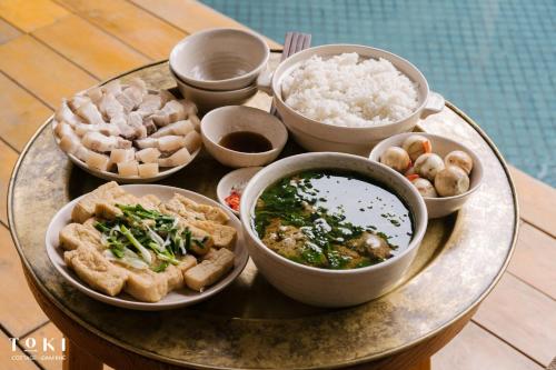 a tray with bowls of food on a table at TOKI Cottage Đam Khê in Vũ Lâm