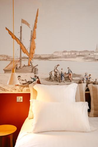 - une chambre avec un lit et une peinture sur un bateau dans l'établissement Magnifique Studio, Bord de mer, Sur la plage, à Pleudihen-sur-Rance