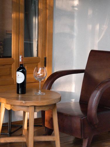 a bottle of wine sitting on a table next to a chair at TOKI Cottage Đam Khê in Vũ Lâm