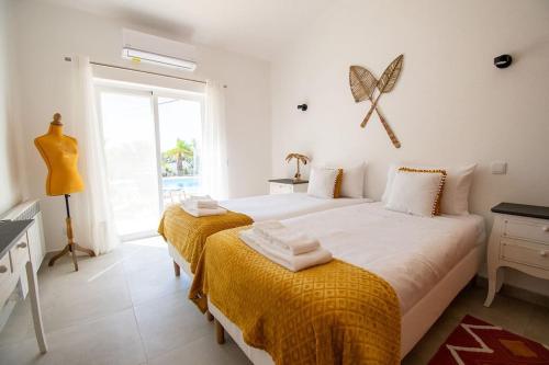 a bedroom with two beds and a window at Pomba beautifully renovated with heated pool! in Poço Partido