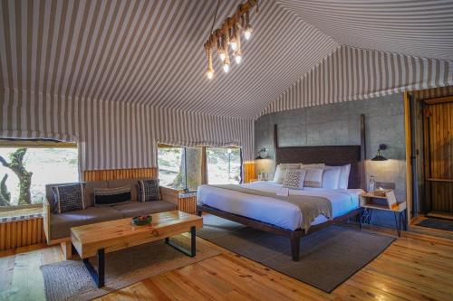 a large bedroom with a bed and a couch at Everest Base Camp, Near George Everest House, 5kms from Library chowk in Mussoorie