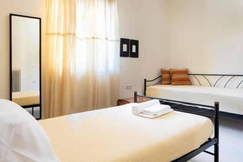 a room with two beds and a mirror at Casa Alta 2-bedroom House in Manoliópoulon