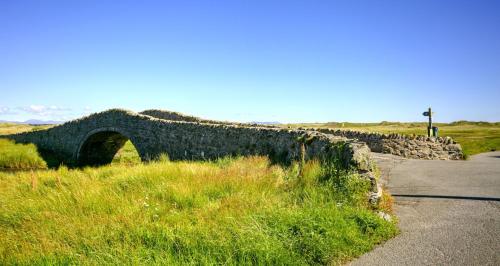 a stone bridge on the side of a road at Cribinau in Aberffraw