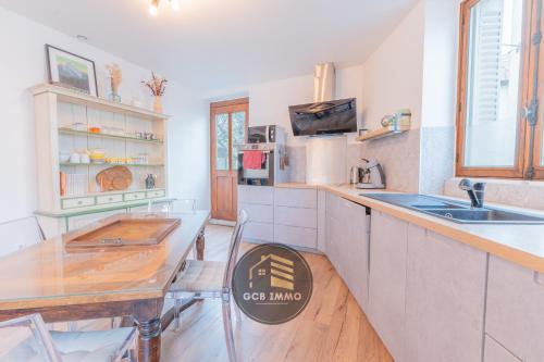 - une cuisine avec une table en bois et un comptoir dans l'établissement Le Garden City - T4 avec Terrasse, à Grenoble