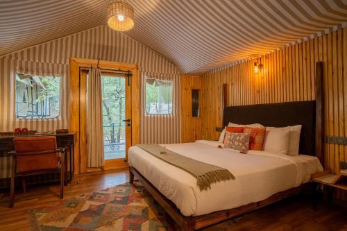 a bedroom with a bed and a desk and windows at Everest Base Camp, Near George Everest House, 5kms from Library chowk in Mussoorie