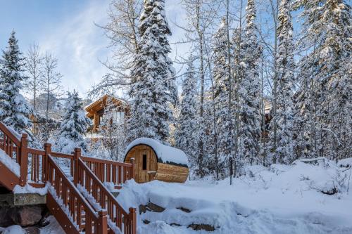 a cabin in the woods with snow on the ground at Copper Horse Lodge in Golden