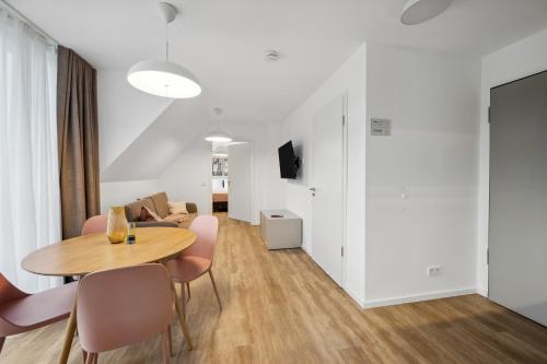 a dining room and living room with a table and chairs at Limehome Karlsruhe Sophienstr in Karlsruhe