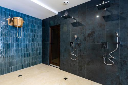 a bathroom with a shower with blue tiled walls at Continental SPA Resort in Bukovel