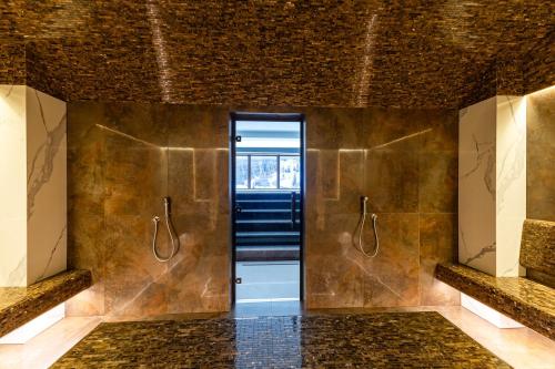 a bathroom with a walk in shower and a door at Continental SPA Resort in Bukovel
