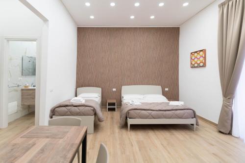 a bedroom with two beds and a table at Toto e Peppino Luxury Rooms in Naples