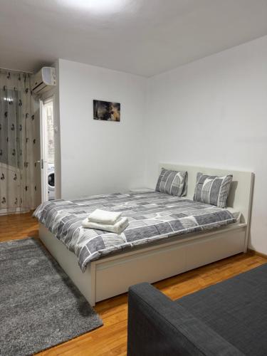 a bedroom with a large bed with a gray rug at National Stadium Aparment in Bucharest