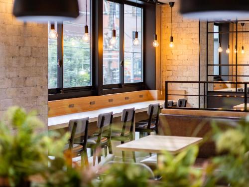 a dining room with tables and chairs and windows at SUPER HOTEL Ikebukuro West Natural Hot Spring in Tokyo