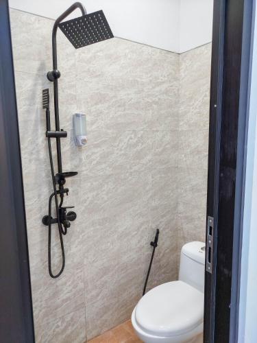 a bathroom with a toilet and a shower at Laswi Syariah Guest House in Bandung