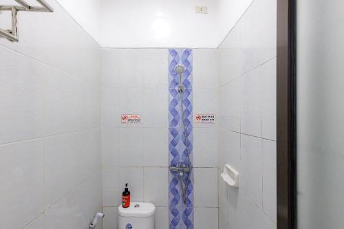 a bathroom with a shower with blue and white tiles at RedDoorz Syariah near Transmart Lampung in Bandar Lampung