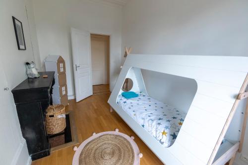 Chambre blanche avec un lit au milieu dans l'établissement Haussmannien Jaurès, à Troyes