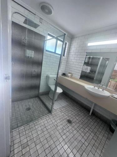 a bathroom with a shower and a toilet and a sink at Albury Garden Court Motel in Albury
