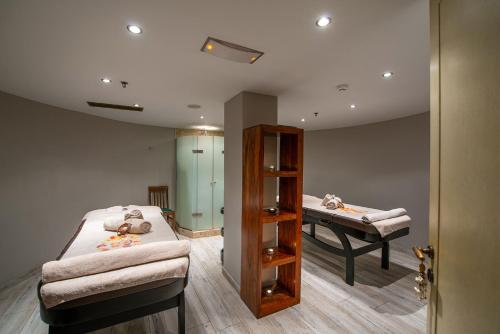a room with two beds and a table in it at Cactus Royal Spa & Resort Adults Only in Stalida