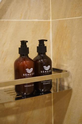 two bottles of soap on a shelf in a bathroom at Seaside Naithon Phuket - Newly Opened in Nai Thon Beach