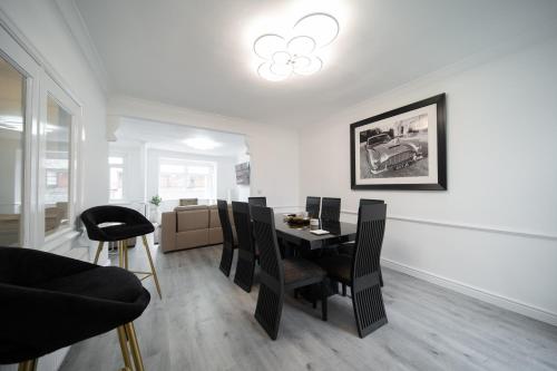 a dining room with a table and black chairs at Spacious Duplex Apartment - Perfectly Situated in the Heart of the City in Blackpool