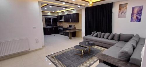 a living room with a couch and a table at Laperla luxury family apartment 4 in Amman