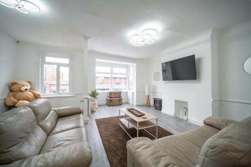 a living room with a teddy bear sitting on a couch at Spacious Duplex Apartment - Perfectly Situated in the Heart of the City in Blackpool