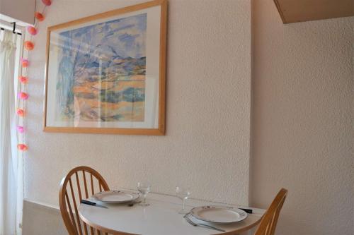une table avec deux chaises et une photo sur le mur dans l'établissement Appartement Studio 2 couchages PORT LEUCATE NATURISME PL010-806, à Leucate-Plage