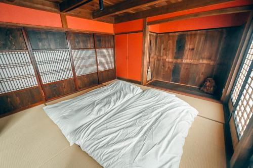 an empty room with a bed in the corner of a room at ツギハギの家 in Itoigawa