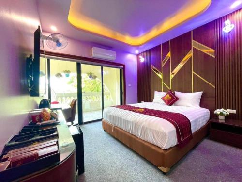 a bedroom with a large bed with a purple ceiling at Rosy Hoàng Mai Hotel in Hanoi