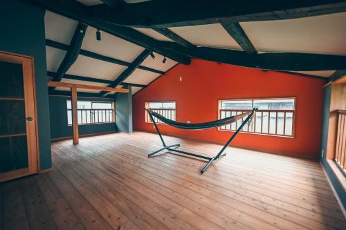 a hammock in a room with red walls at ツギハギの家 in Itoigawa