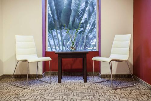 two white chairs and a table with a vase on it at NH Coatzacoalcos in Coatzacoalcos