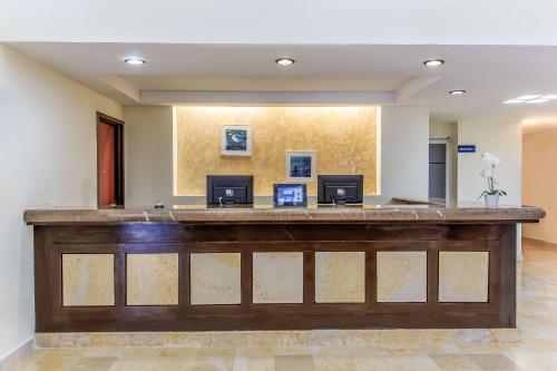 a large lobby with a large wooden reception desk at NH Coatzacoalcos in Coatzacoalcos