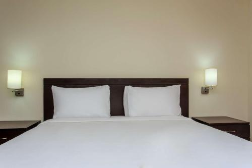 a large bed with white sheets and two night stands at NH Coatzacoalcos in Coatzacoalcos
