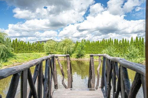a wooden bridge over a body of water at Egliškių Oazė Sodyba su pirtimi kubilu- privatumas garantuotas in Vilnius