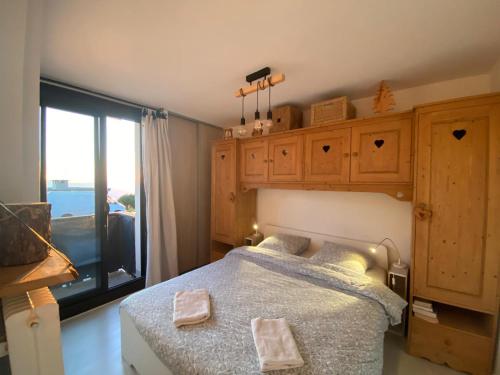 een slaapkamer met een bed en een groot raam bij Appartement 8 personnes 3 chambres 1 750 m altitude in Chamrousse