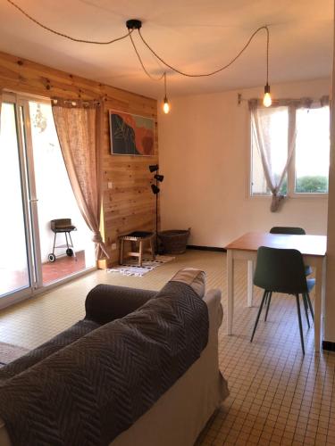 un salon avec un canapé et une table dans l'établissement LE DROP IN - T2 au RDC avec terrasse à 200m de la plage - Well located apartment for surfers, à Mimizan-Plage