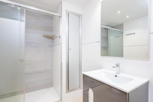 a white bathroom with a sink and a shower at Albers in Playa de Muro